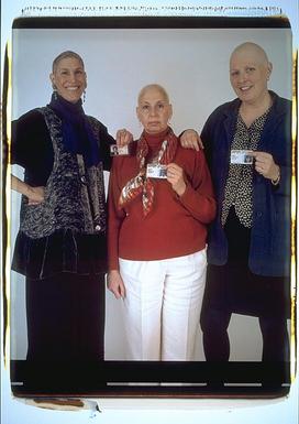All three, standing and holding up their drivers licenses for the camera.